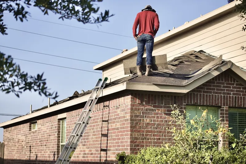 Professional roofer working on a residential roof in Caryn